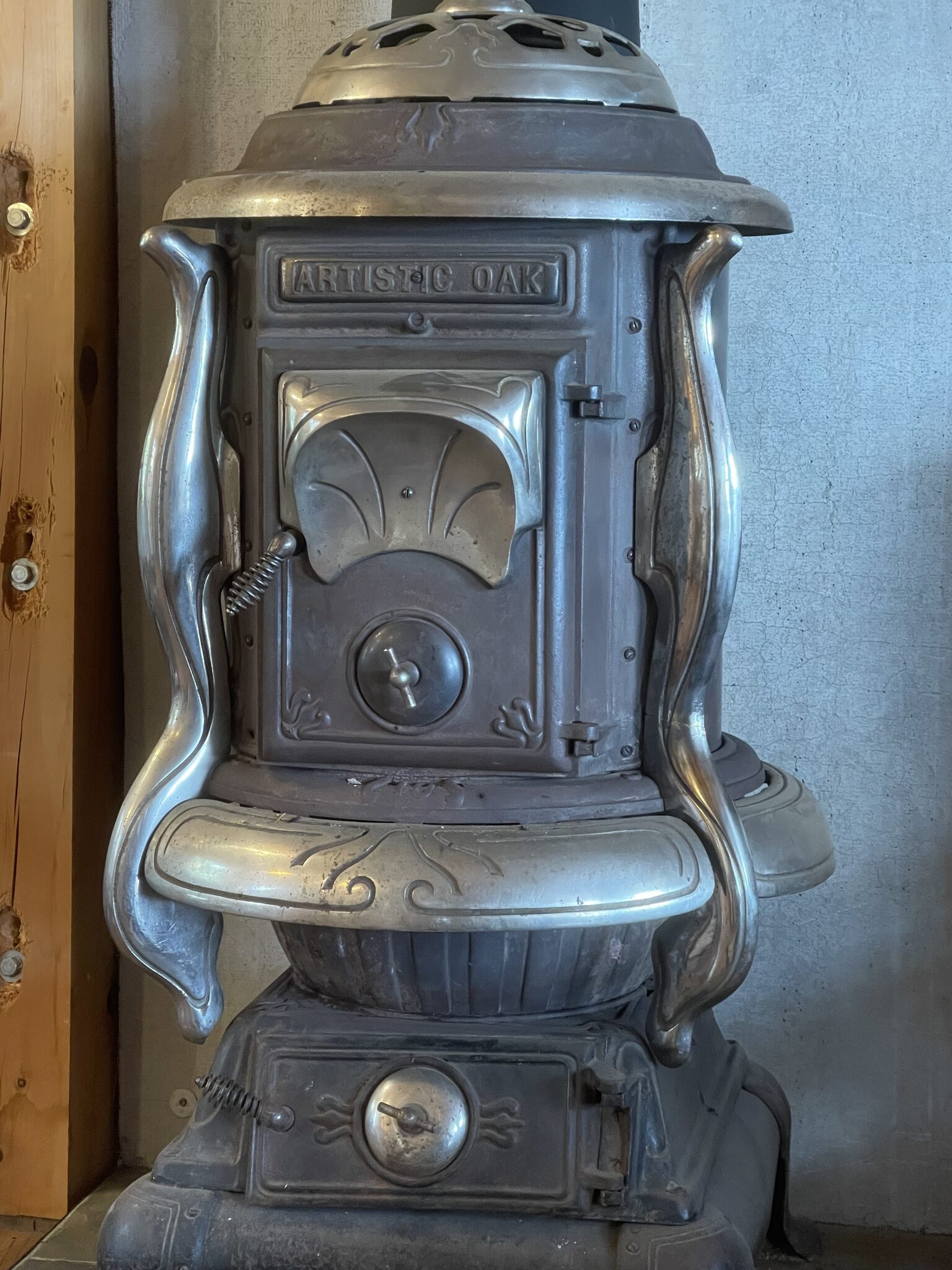 An ornate antique Artistic Oak nickel-and-cast-iron parlor stove in the Main Cabin at Sweetwater Ranch