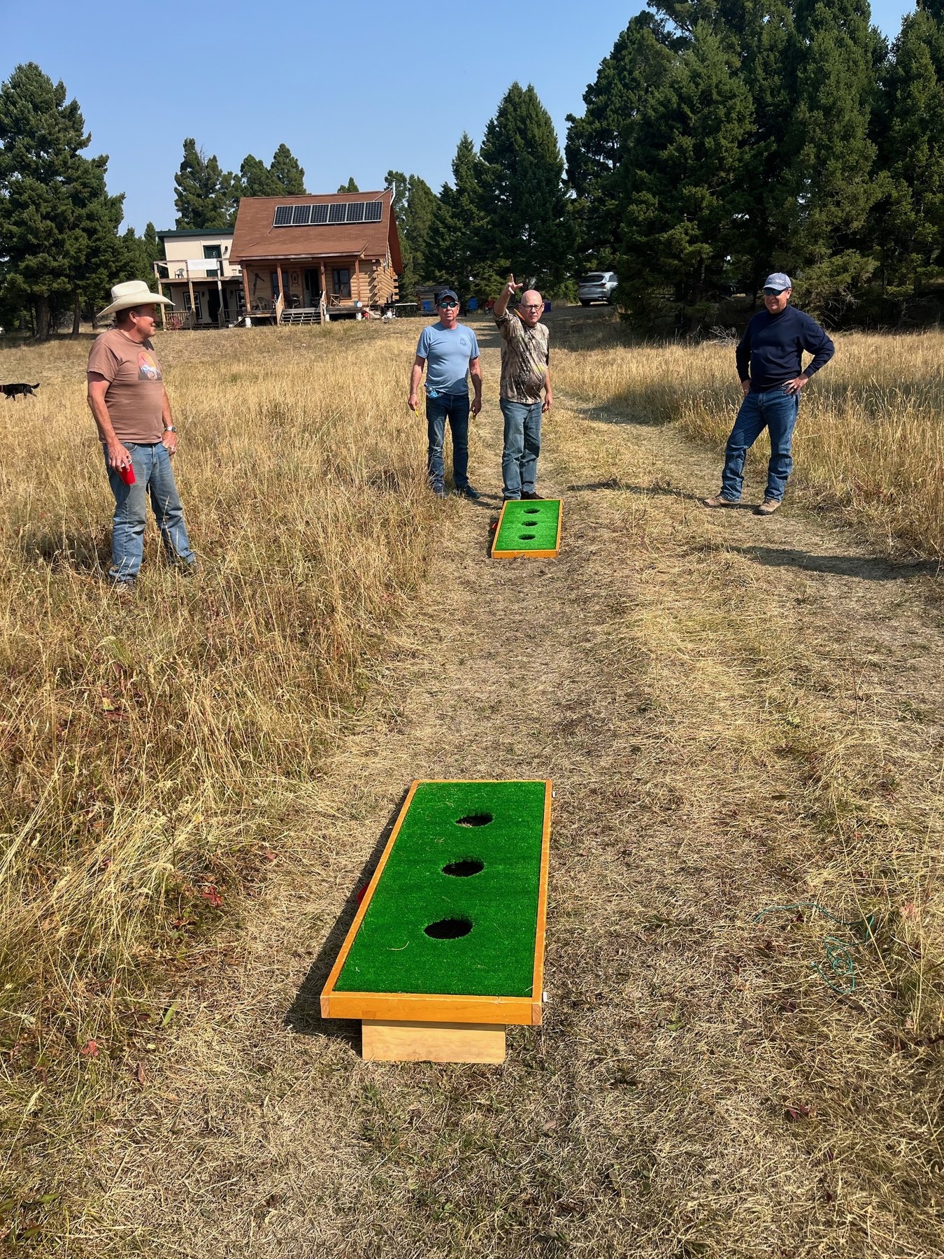 Guests playing beanbag toss in the high meadow at Sweetwater Ranch