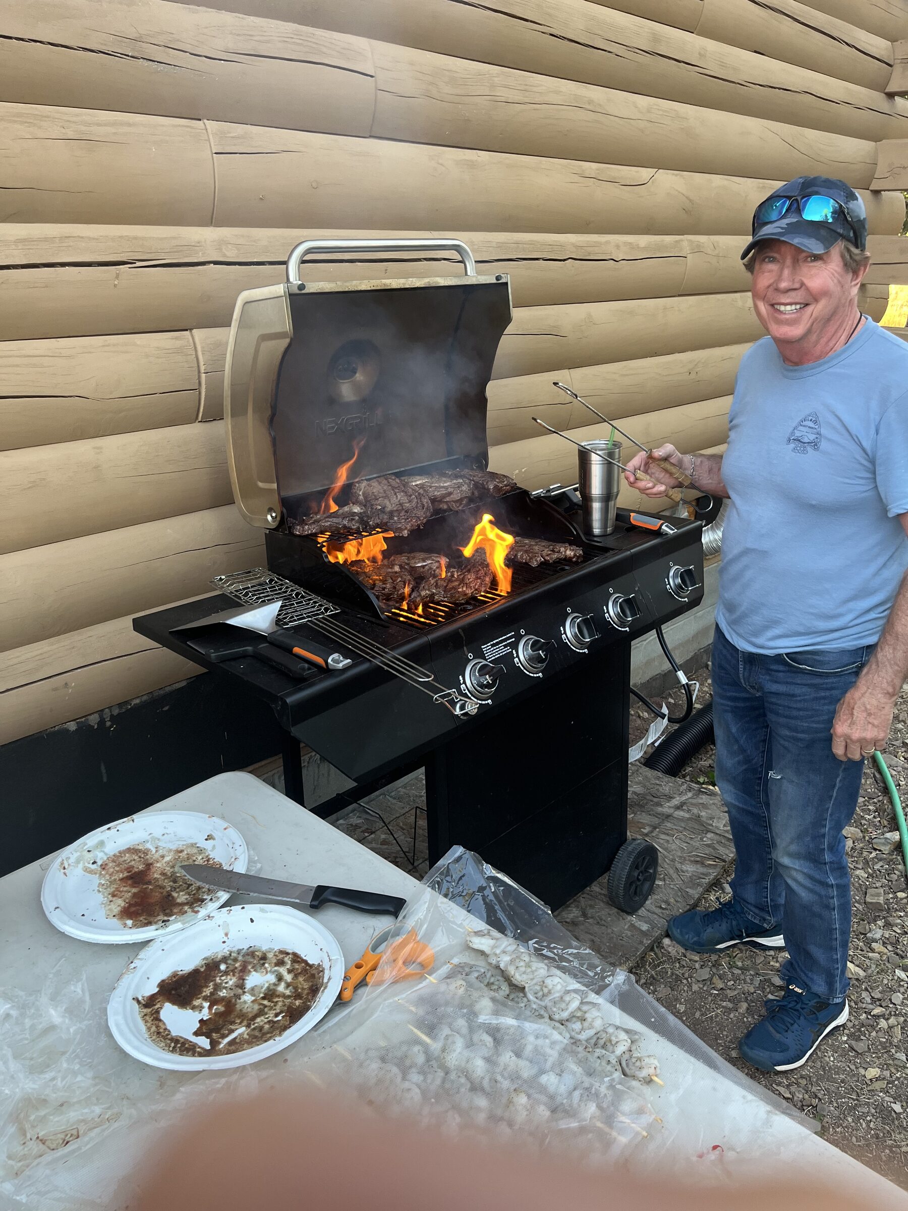 The owner grilling steaks over an open flame at the ranch