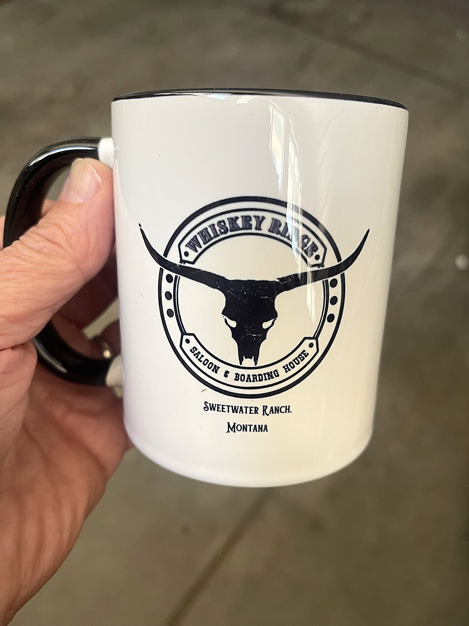A Whiskey Ridge Saloon & Boarding House mug — the longhorn-skull stamp, Sweetwater Ranch, Montana