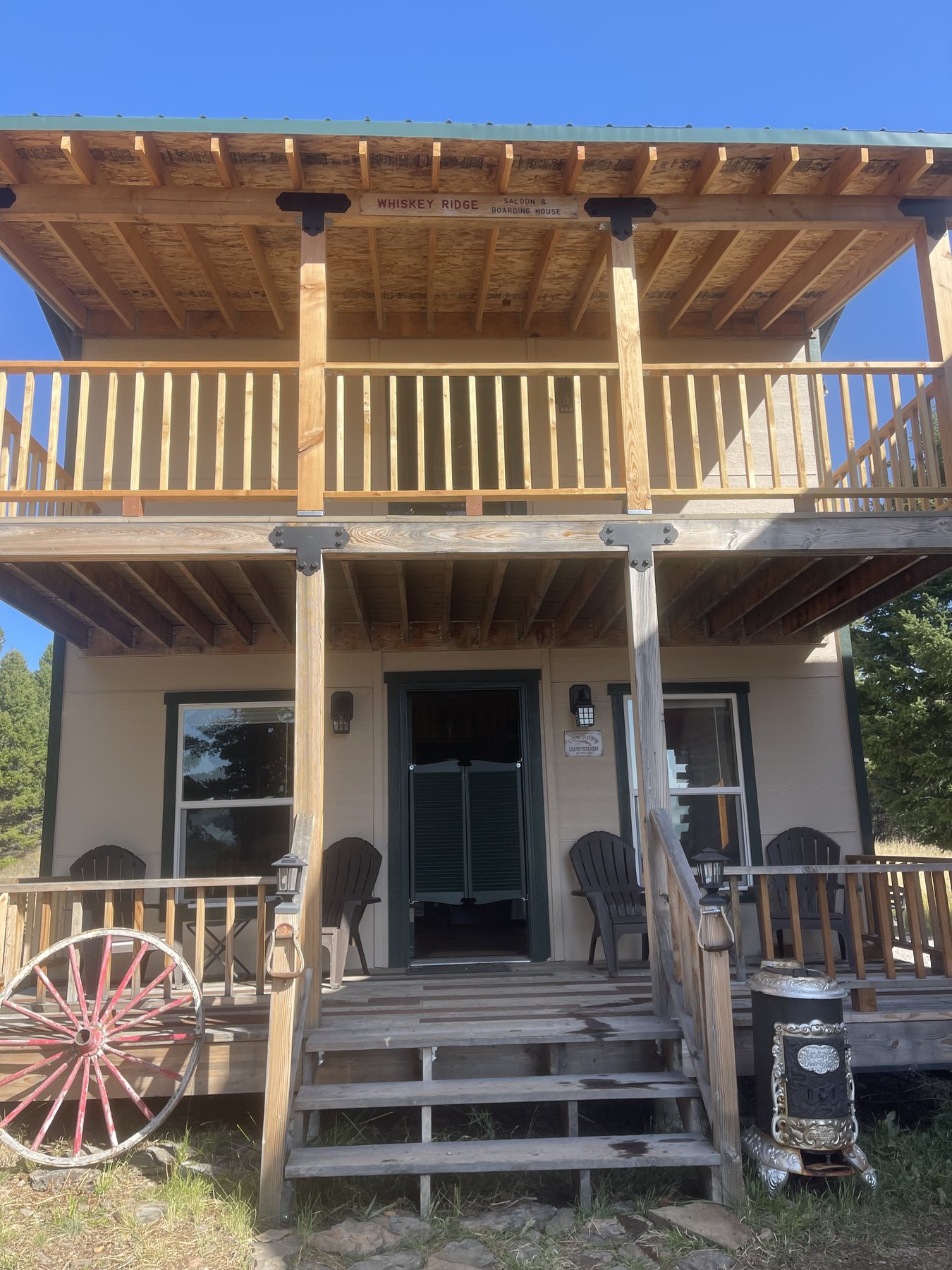 The Whiskey Ridge Saloon & Boarding House at Sweetwater Ranch, green swinging doors and a balcony over the porch
